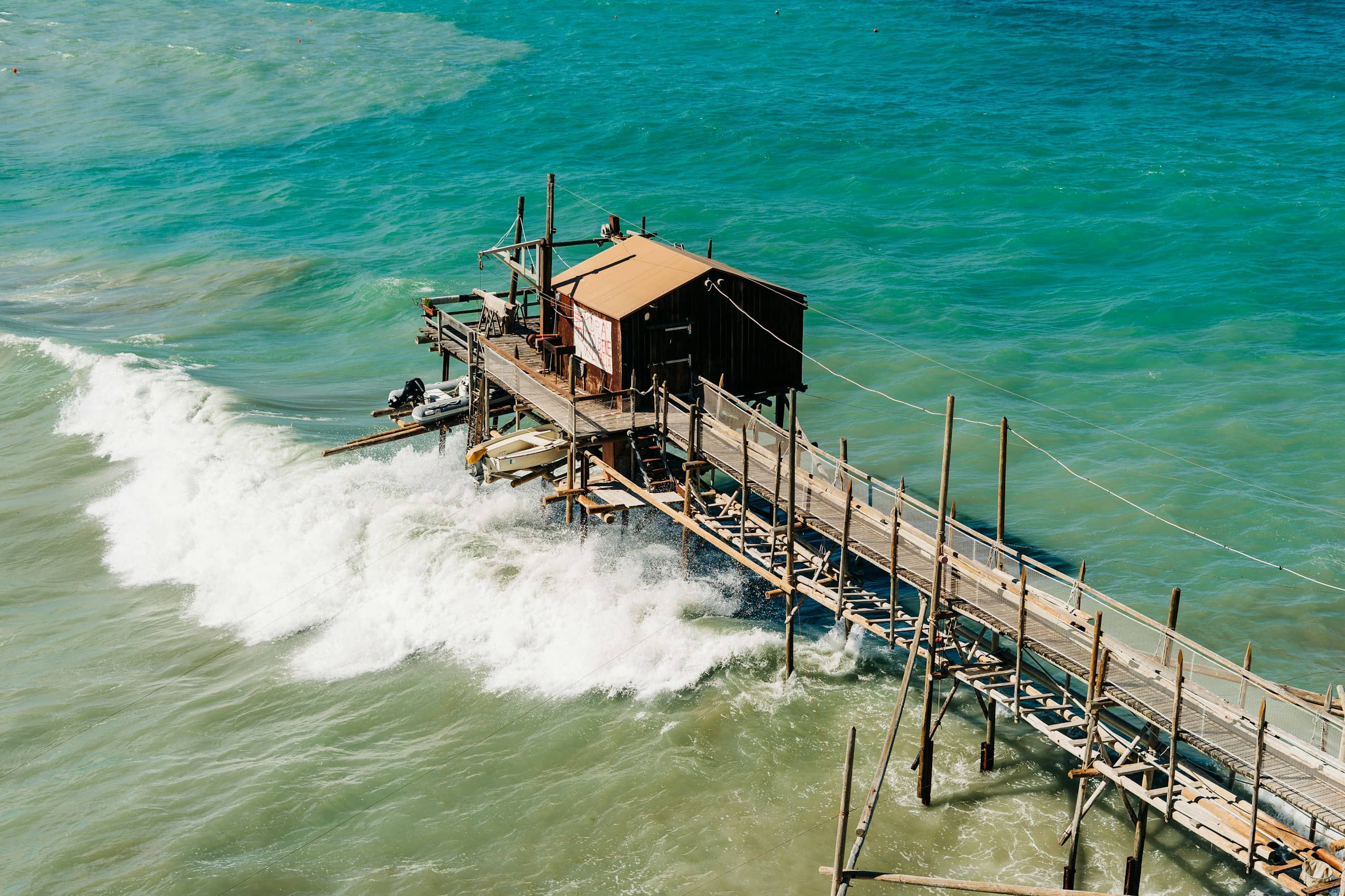 A trabucco, the timber fishing platform on stilts, standing in breaking surf on the Molise coast.